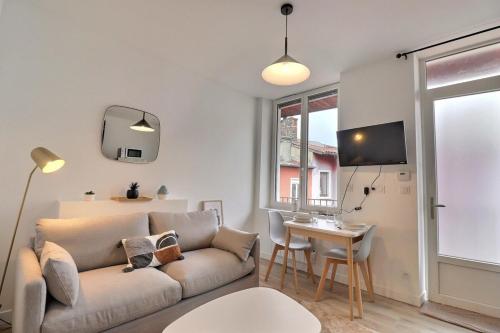 un salon avec un canapé et une table dans l'établissement Degemer - T1 Apartment in Charpennes - Villeurbanne, à Villeurbanne