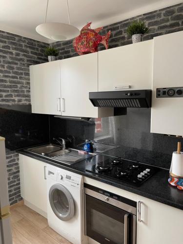 una cocina con estufa y lavadora en Appart de Manuela, en Saint-Malo