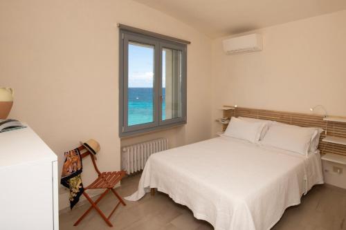a bedroom with a bed and a window and a chair at Riva Mediterranea in Otranto