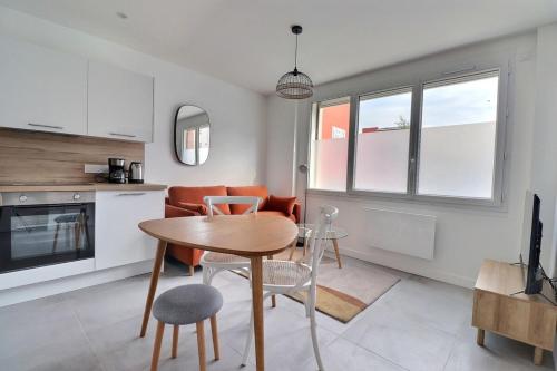 une cuisine et une salle à manger avec une table et des chaises dans l'établissement Les Mimosas - T2 Ground Floor Apartment - Villeurbanne, à Villeurbanne