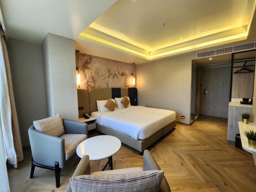 a hotel room with a bed and a couch and a table at Dragonfly Hotel- The Art Hotel in Mumbai