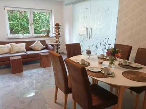 a dining room with a table and chairs and a couch at Wohlfühloase Ermreuth in Neunkirchen am Brand