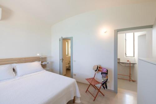a bedroom with a white bed and a chair at Riva Mediterranea in Otranto