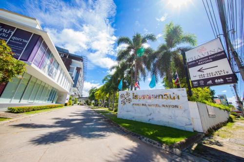 a street in front of a building with palm trees at Phavina Grand Boutique in Rayong