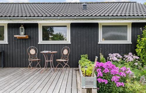 a black house with two chairs and a table on a deck at 2 Bedroom Gorgeous Home In Grevinge in Grevinge