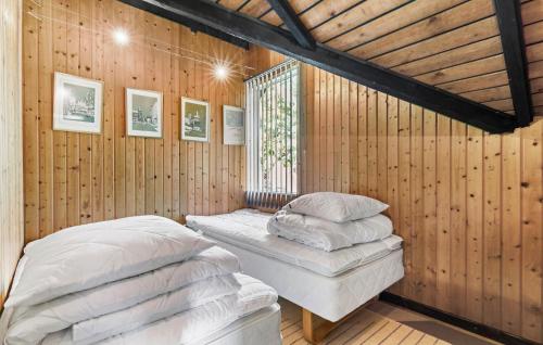 two beds in a room with wooden walls at 2 Bedroom Lovely Home In Melby in Melby