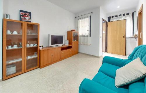 a living room with a blue couch and a television at 1 Bedroom Lovely Apartment In Vinaroz in Vinaròs