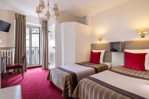 a hotel room with two beds with red pillows at Hôtel Saint Pierre in Paris