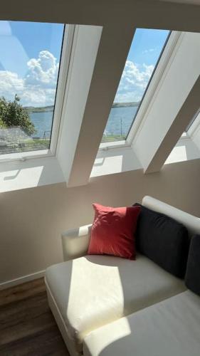a living room with a couch and two windows at Ferienwohnung am Meer! in Alt Reddevitz