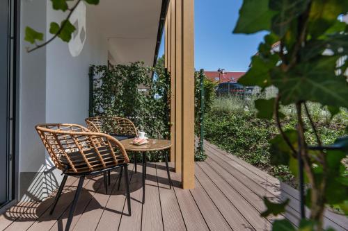 a table and two chairs on a porch with a patio at Rezydencja Merwede Aparthotel - My Rest in Gdańsk