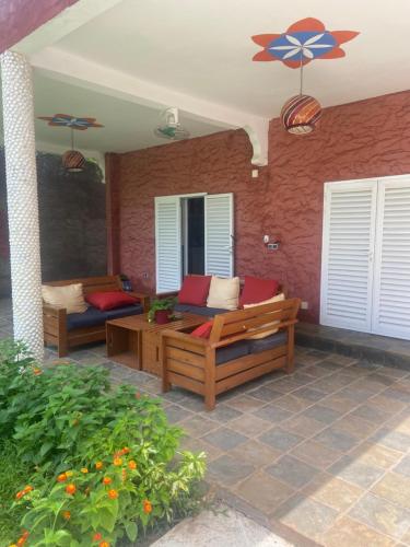 a patio with two wooden benches on a brick wall at Villa Madibso in Mbour
