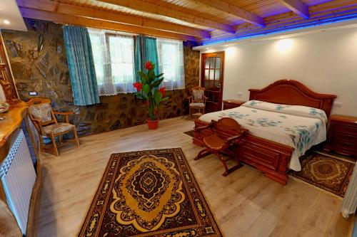a bedroom with a bed and a table and a rug at Vila Victoria in Pangarati