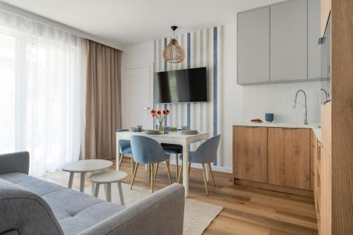 a kitchen and a living room with a table and chairs at Rezydencja Merwede Aparthotel - My Rest in Gdańsk