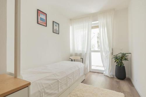 Un dormitorio blanco con una cama y una ventana. en Libra Light, en Udine