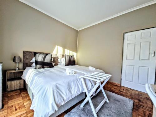 a bedroom with a bed with white sheets at 9 on Drommedaris in Stellenbosch