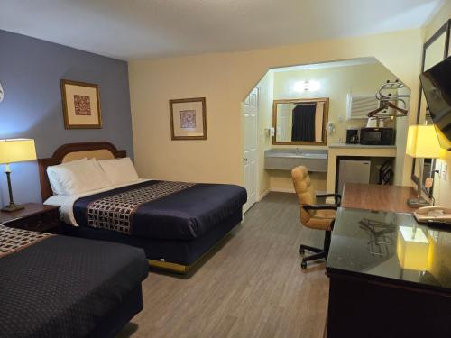 a hotel room with two beds and a desk at Rodeway Inn & Suites Blythe I-10 in Blythe
