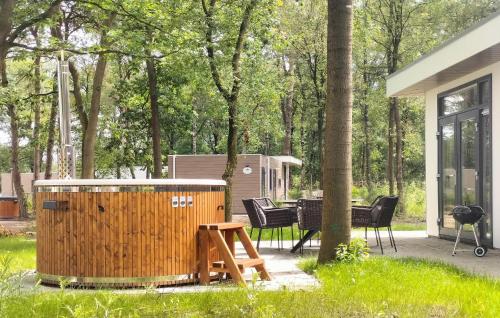 a wooden barrel in a yard with chairs and a table at Lovely Home In Hellendoorn With Kitchen in Hellendoorn
