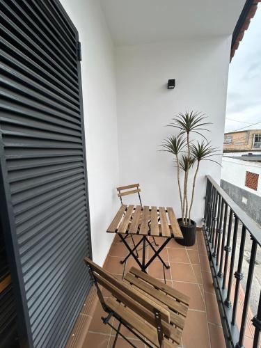 a balcony with a wooden bench and a table at Casa Mariquilla in Sanlúcar de Barrameda