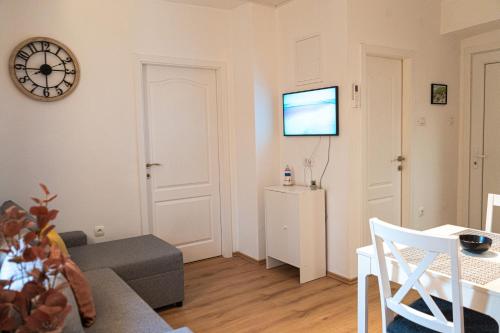 a living room with a couch and a tv on the wall at Sunny Bay Apartment in Rijeka