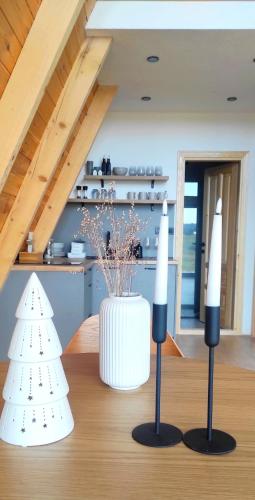 two candles on top of a table with a vase at Hill House Žabljak in Žabljak