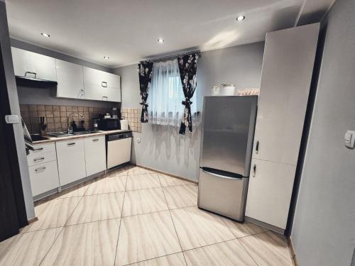 a kitchen with white cabinets and a refrigerator at Smile Apart in Biały Dunajec
