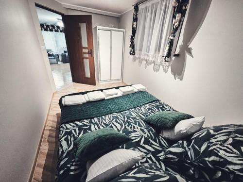 a bedroom with a bed with green and white pillows at Smile Apart in Biały Dunajec