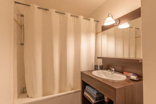 une salle de bain avec un lavabo et un rideau de douche dans l'établissement Studio Disneyland Paris, à Montévrain