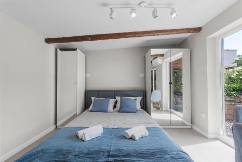 a bedroom with a blue bed with two pillows at Süßes Ferienhaus mit Privatpool, Sonnenterrasse, BBQ in Strandnähe in Karpinjan