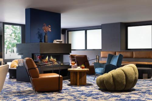 a living room with chairs and a fireplace at Hôtel Best of Both - Divonne-les-Bains in Divonne-les-Bains