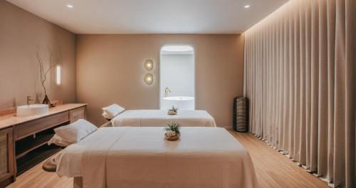 a hotel room with two beds and a sink at VALA Hua Hin - Nu Chapter Hotels in Cha Am