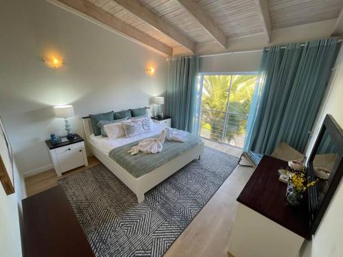 ein Schlafzimmer mit einem Bett und einem großen Fenster in der Unterkunft Waterfront Cottage B2 in Swakopmund