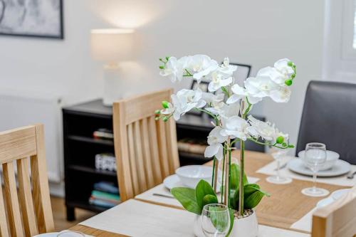a dining room table with a vase with white flowers at Cowden Coorie in Fife