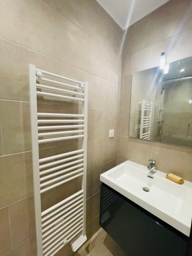 une salle de bain avec un lavabo et un miroir dans l'établissement Appartement pour deux personnes, à Sisteron