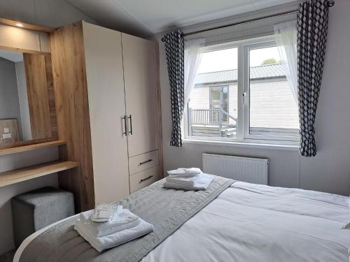 a bedroom with a bed with two towels on it at Addlethorpe Golf & Country Club, Ingoldmells in Addlethorpe