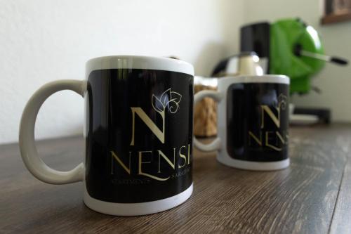 two black and white coffee mugs sitting on a table at APARTMENTS NENSI in Sarajevo