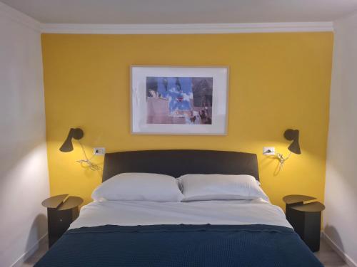 a bedroom with a bed with a yellow wall at La Controra Hostel Naples in Naples