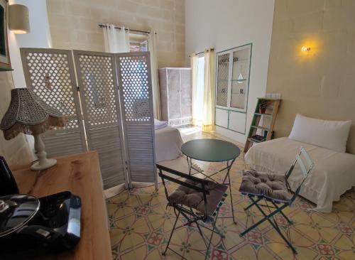 a living room with a bed and a table and chairs at Serene Respite close to Rabat in Kerċem