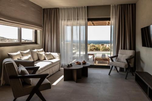 a living room with a couch and a large window at Ela Tinos in Arnados