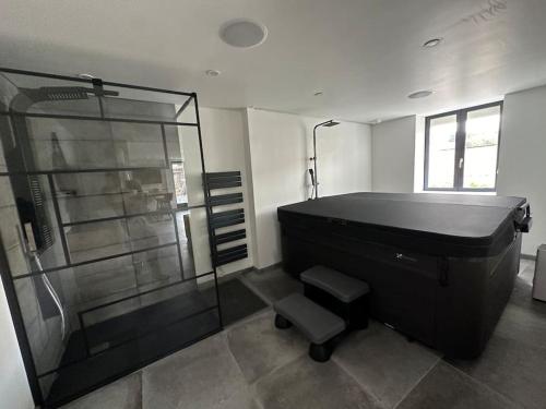 a bathroom with a tub and a glass shower at Maison de charme, pierres blanches, SPA Jaccuzi in Camblain-lʼAbbé