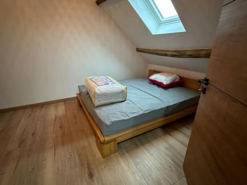 a small bedroom with a bed in a attic at Maison de charme, pierres blanches, SPA Jaccuzi in Camblain-lʼAbbé