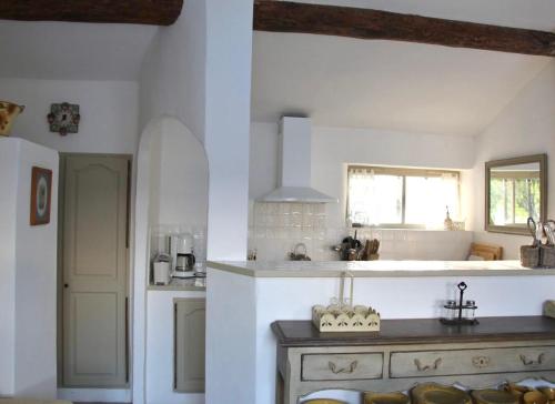 Biała kuchnia ze zlewem i kuchenką w obiekcie Charming Provençal farmhouse with pool w mieście Mérindol