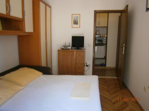 a bedroom with a white bed and a television at Villa Miranda - Croazia in Omiš