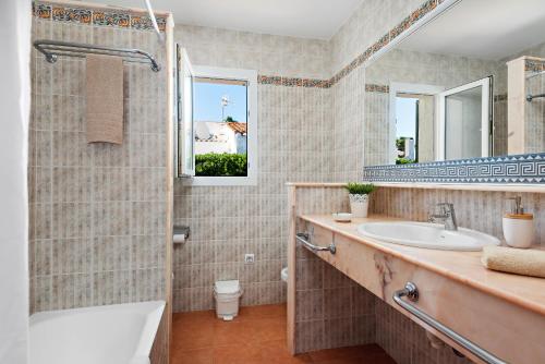 a bathroom with a sink and a shower at Villas Begonias in Cala'n Bosch