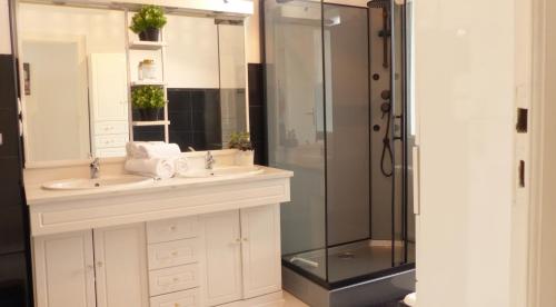 ein Badezimmer mit zwei Waschbecken und einer Dusche in der Unterkunft Charmante maison de vacances - Le Bono in Le Bono