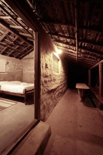 a dark room with a bed and a window at The Soul Marayoor Mudhouse - Munnar in Marayoor