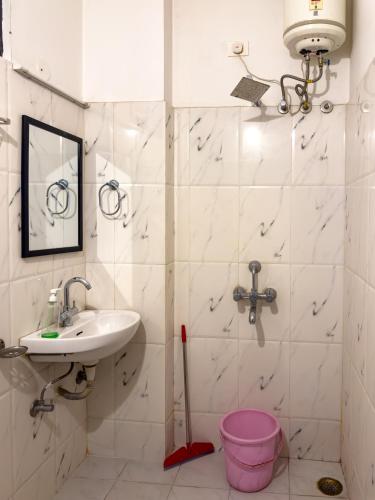 a bathroom with a sink and a shower with a pink bucket at Madpackers Udaipur in Udaipur