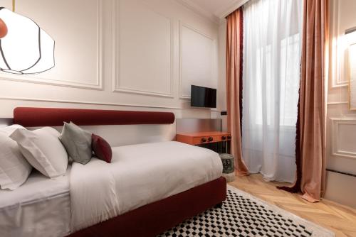 a bedroom with a bed and a television and a window at The Couper Umiltà in Rome