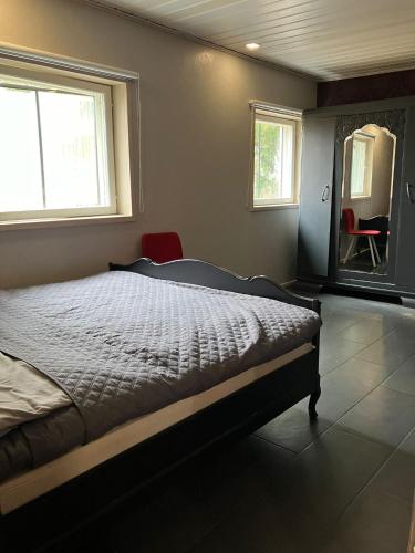 a bedroom with a bed in a room with two windows at Erillistalo keskustassa in Seinäjoki