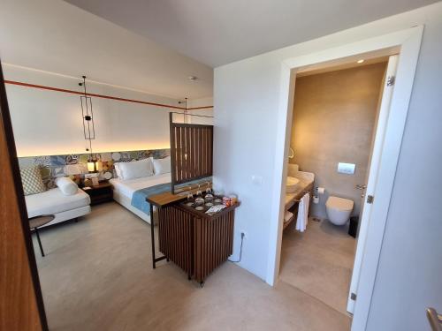 a hotel room with a bed and a bathroom at Folie Marine Hotel & Beach Club in Jal