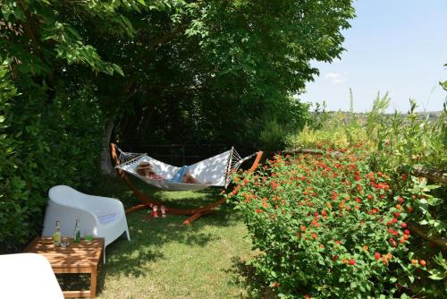 a person laying in a hammock in a garden at Antico Convento Dei Cappuccini in Ragusa